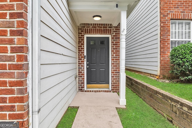 2849 Windsor Forrest Ct, Atlanta, GA 30349 - doorway to property featuring brick siding and a surveillance system