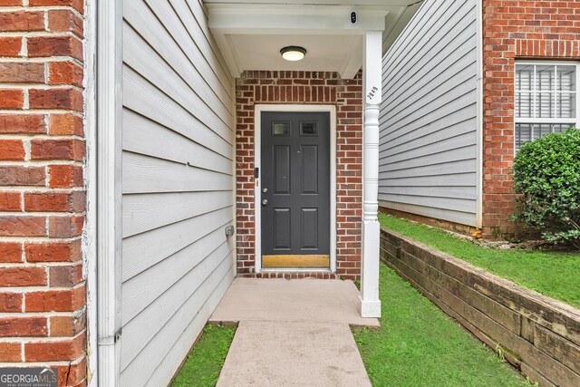2849 Windsor Forrest Ct, Atlanta, GA 30349 - doorway to property featuring brick siding and a security system