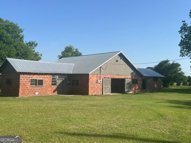570 July Rd, Rochelle, GA 31079 - back of property featuring a lawn, metal roof, a barn, a garage, and an outbuilding