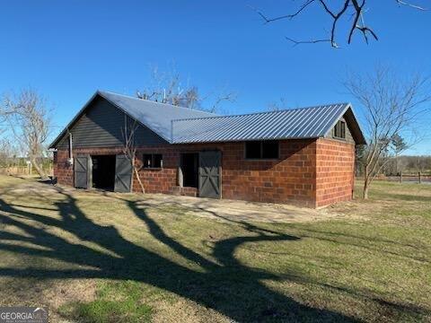 570 July Rd, Rochelle, GA 31079 - rear view of property with a lawn and metal roof