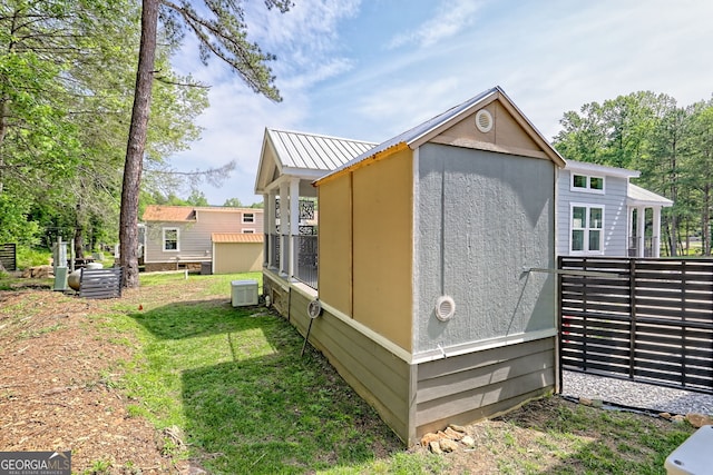 view of side of property featuring an outdoor structure, a storage shed, and central AC unit