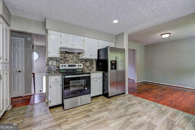 kitchen featuring appliances with stainless steel finishes, under cabinet range hood, a textured ceiling, light wood finished floors, and backsplash