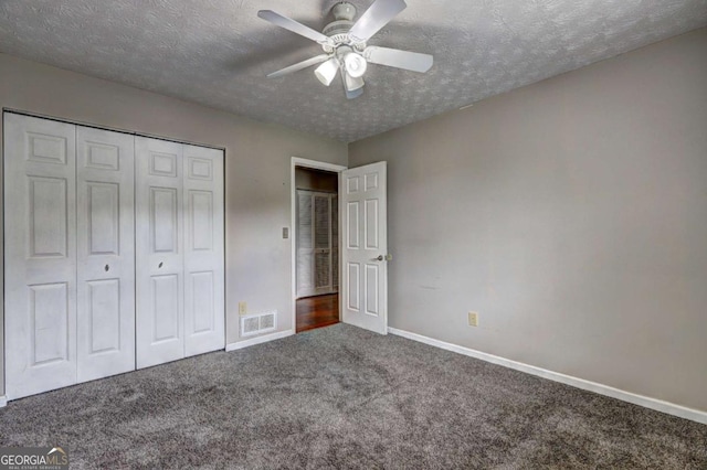unfurnished bedroom with carpet flooring, a textured ceiling, baseboards, a closet, and a ceiling fan