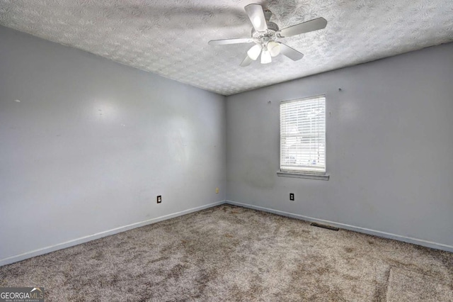 carpeted spare room featuring a textured ceiling, baseboards, and a ceiling fan