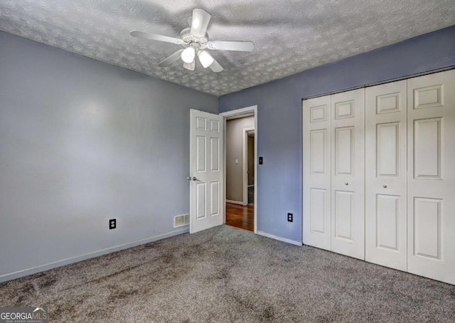 unfurnished bedroom featuring carpet floors, a textured ceiling, baseboards, a closet, and ceiling fan