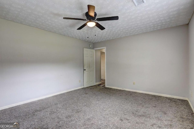 carpeted spare room featuring baseboards, ceiling fan, and a textured ceiling