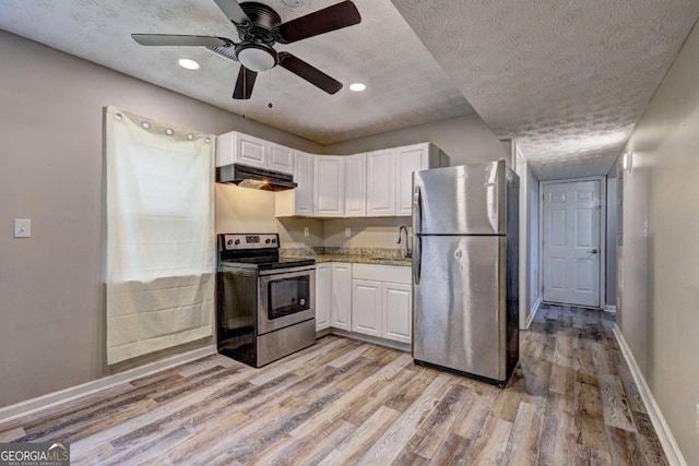 kitchen with stainless steel appliances, under cabinet range hood, baseboards, white cabinets, and a textured ceiling