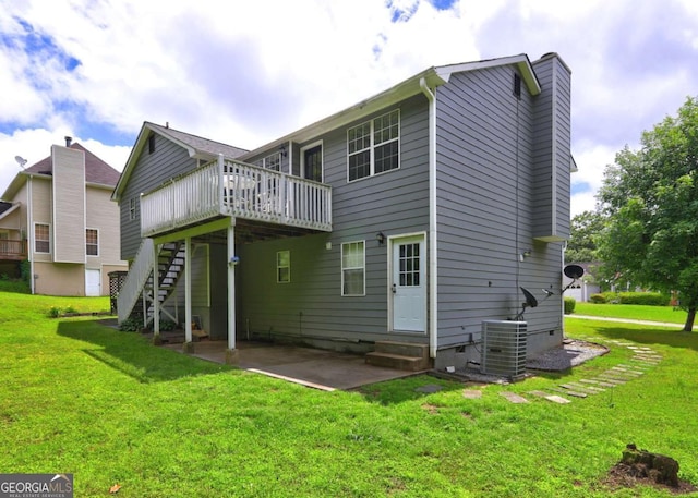 back of property with central AC unit, a wooden deck, a lawn, stairway, and a patio