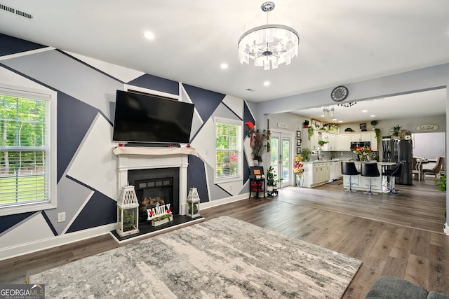 100 Chadwick Pl, Villa Rica, GA 30180 - living room with a chandelier, wood finished floors, baseboards, a fireplace with raised hearth, and recessed lighting