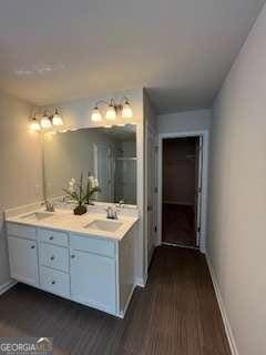 4263 Notting Hill Dr SW, Atlanta, GA 30331 - full bath with baseboards, a shower stall, wood finished floors, and double vanity