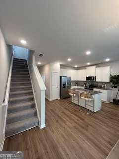 4263 Notting Hill Dr SW, Atlanta, GA 30331 - kitchen with freestanding refrigerator, white cabinets, dark wood-style flooring, recessed lighting, and dark countertops