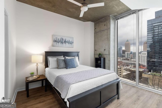 855 Peachtree St NE Unit 1508, Atlanta, GA 30308 - bedroom with floor to ceiling windows, wood finished floors, a view of city, and a ceiling fan