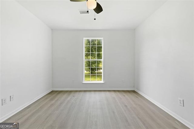 unfurnished room with wood finished floors, ceiling fan, and baseboards