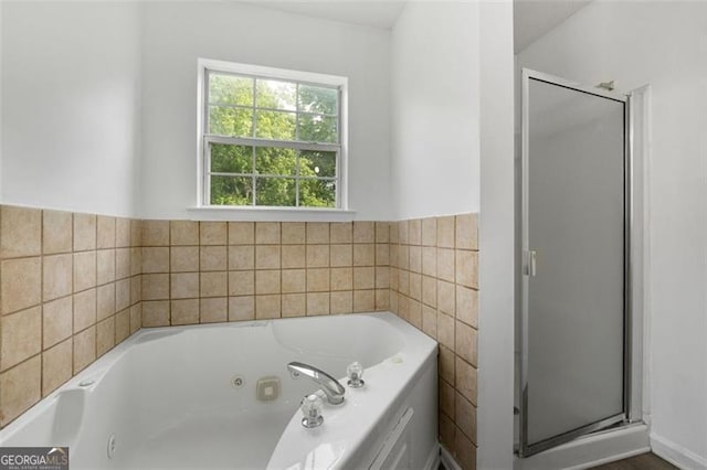 full bathroom featuring a whirlpool tub and a stall shower