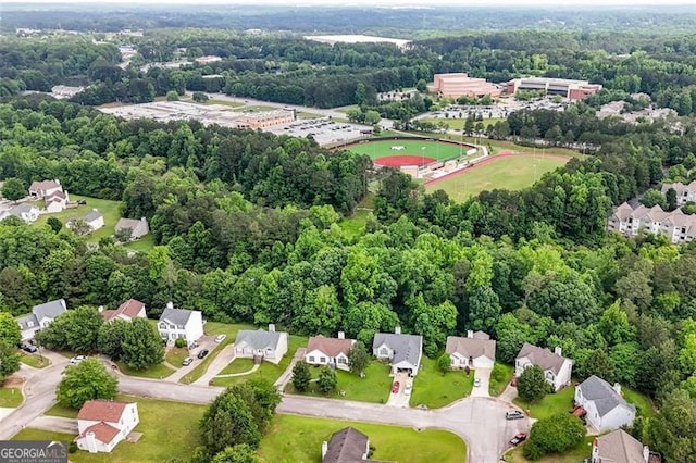aerial view of property's location featuring a forest and nearby suburban area