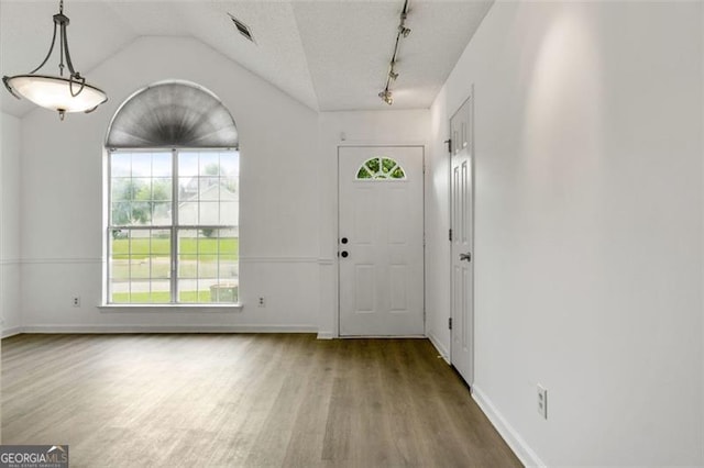 entryway featuring wood finished floors, baseboards, track lighting, and lofted ceiling