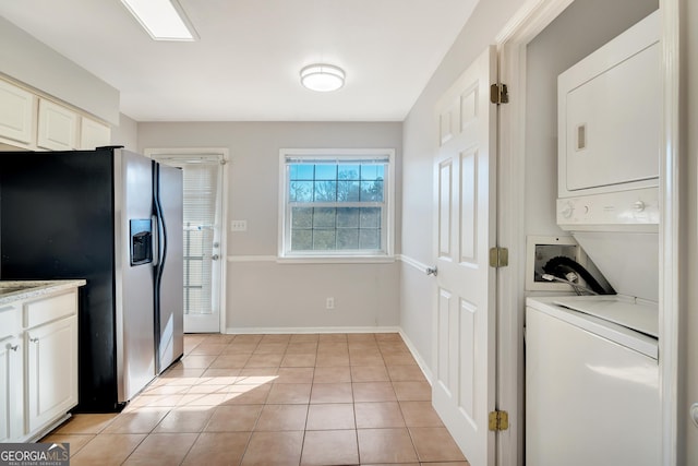 3137 Buford Hwy NE Unit 11, Brookhaven, GA 30329 - laundry room featuring stacked washer / dryer, light tile patterned floors, and baseboards