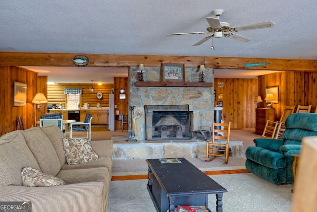 carpeted living room with a ceiling fan, wooden walls, a fireplace, a textured ceiling, and rustic walls