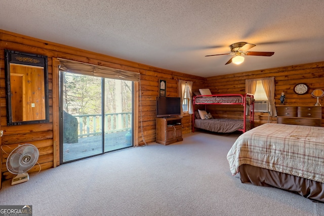 bedroom featuring access to outside, a textured ceiling, carpet, rustic walls, and cooling unit