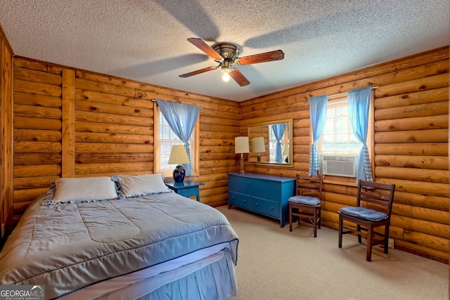 bedroom featuring a textured ceiling, multiple windows, carpet flooring, and cooling unit