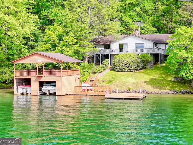 dock featuring a water view, a forest view, and stairs