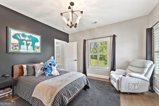 6815 Berkley Rd, Cumming, GA 30040 - bedroom with a chandelier, wood finished floors, and baseboards