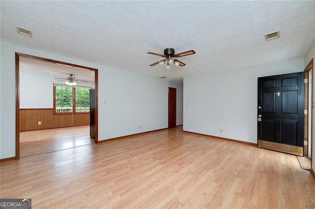 1810 King Mill Rd, Mcdonough, GA 30252 - spare room featuring ceiling fan, light wood-type flooring, a textured ceiling, a wainscoted wall, and baseboards