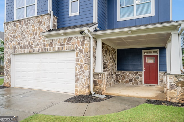 1946 Jeffery Rd NW, Atlanta, GA 30318 - entrance to property featuring stone siding, an attached garage, covered porch, and board and batten siding