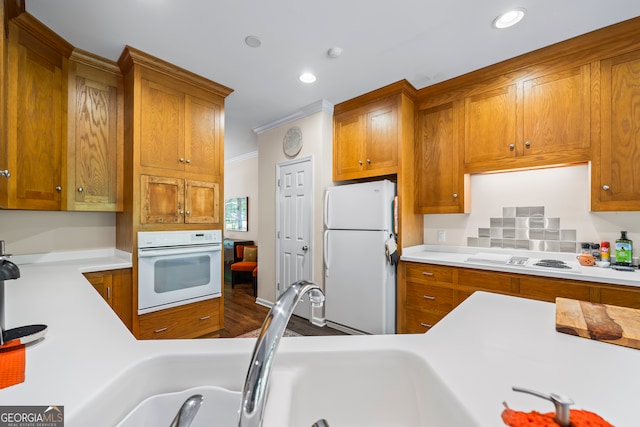 127 Chestnut Ln, Athens, GA 30606 - kitchen with white appliances, light countertops, brown cabinets, recessed lighting, and crown molding