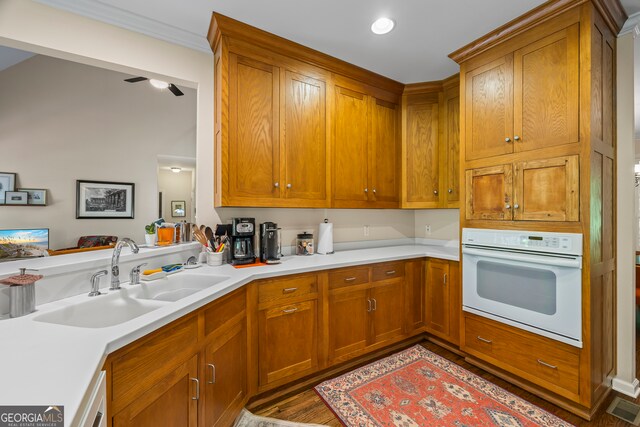 127 Chestnut Ln, Athens, GA 30606 - kitchen with white oven, light countertops, brown cabinets, and crown molding