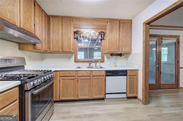 2652 Mount Tabor Church Rd, Dallas, GA 30157 - kitchen with stainless steel gas range oven, dishwasher, under cabinet range hood, a sink, and light wood finished floors