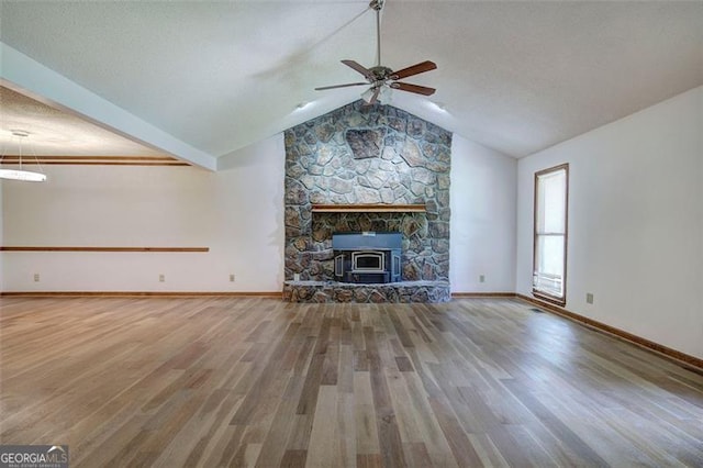 2652 Mount Tabor Church Rd, Dallas, GA 30157 - unfurnished living room with wood finished floors, ceiling fan, vaulted ceiling, a wood stove, and baseboards