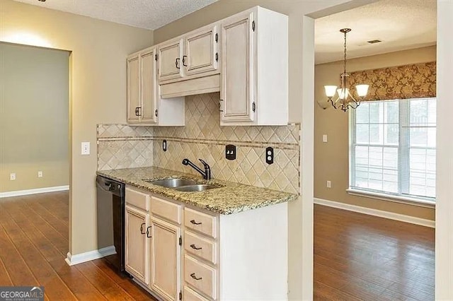 kitchen featuring black dishwasher, a sink, dark wood finished floors, tasteful backsplash, and light stone counters