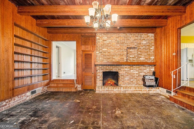 894 Nottingham Dr, Avondale Estates, GA 30002 - unfurnished living room with wooden walls, wood ceiling, a chandelier, beam ceiling, and a brick fireplace