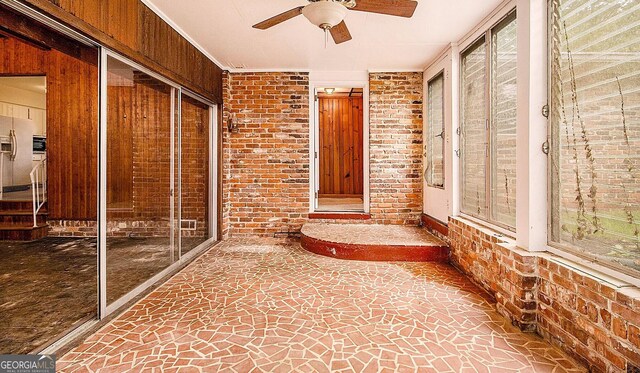 894 Nottingham Dr, Avondale Estates, GA 30002 - unfurnished sunroom with brick wall, a ceiling fan, and stone flooring