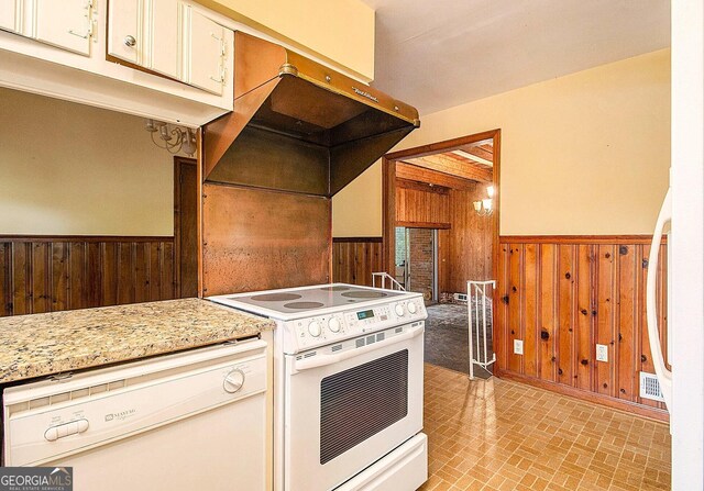 894 Nottingham Dr, Avondale Estates, GA 30002 - kitchen featuring white appliances, wood walls, a wainscoted wall, under cabinet range hood, and brick patterned flooring