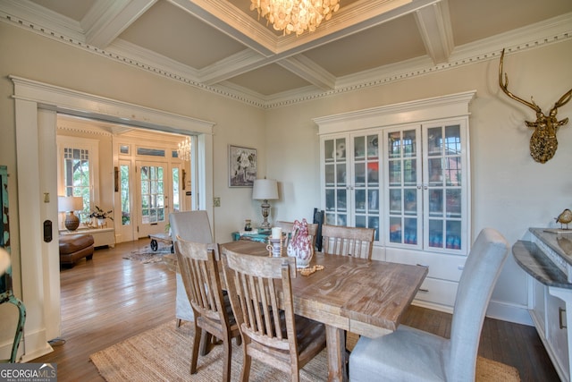 dining area with coffered ceiling, a chandelier, french doors, beam ceiling, and wood finished floors
