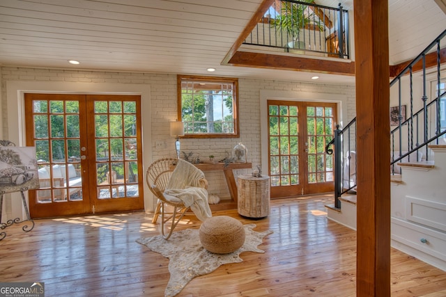 interior space with french doors, wooden ceiling, stairway, brick wall, and wood-type flooring