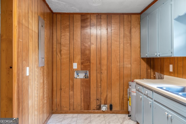 laundry area featuring wooden walls, cabinet space, light marble finish flooring, and washer hookup