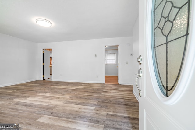 foyer with light wood-type flooring and baseboards