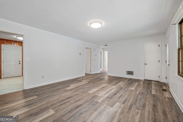 unfurnished living room featuring wood finished floors and baseboards