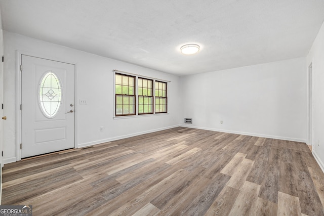 entrance foyer featuring wood finished floors, healthy amount of natural light, and baseboards