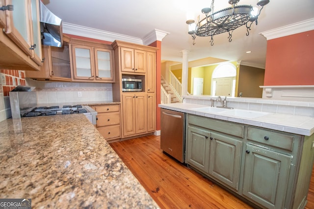 24 Overbrook Ct, Newnan, GA 30263 - kitchen featuring appliances with stainless steel finishes, wall chimney range hood, tasteful backsplash, ornamental molding, and light wood-style flooring