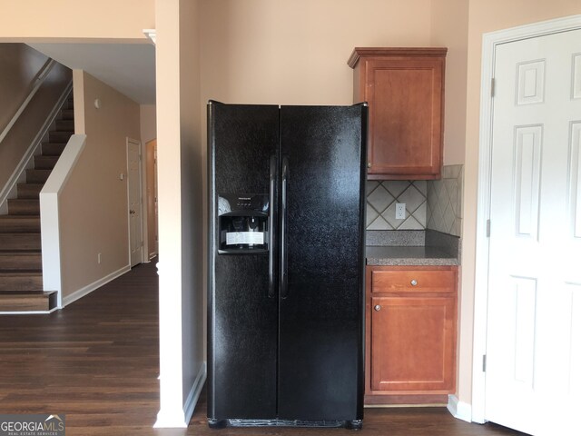 1938 Dilcrest Dr, Duluth, GA 30096 - kitchen featuring black fridge, dark wood-style floors, brown cabinetry, backsplash, and baseboards