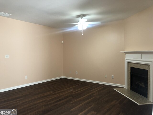 1938 Dilcrest Dr, Duluth, GA 30096 - unfurnished living room with dark wood finished floors, ceiling fan, a fireplace with raised hearth, and baseboards