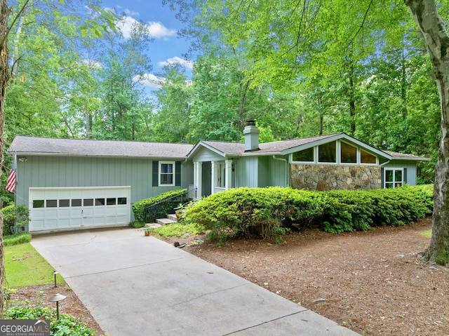 1260 Willeo Creek Dr, Roswell, GA 30075 - view of front of house with a chimney, driveway, a garage, stone siding, and a shingled roof