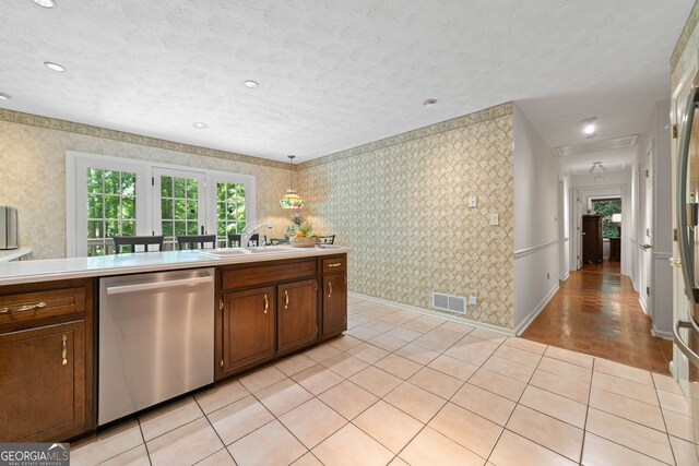 1260 Willeo Creek Dr, Roswell, GA 30075 - kitchen with stainless steel dishwasher, wallpapered walls, light countertops, light tile patterned flooring, and a textured ceiling