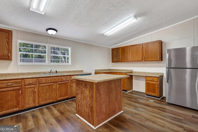 27 Pocahontas Rd, Midway, GA 31320 - kitchen featuring freestanding refrigerator, vaulted ceiling, a sink, a textured ceiling, and brown cabinets