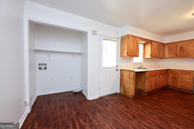1309 Newton Rd, Albany, GA 31701 - kitchen featuring brown cabinets, dark wood-type flooring, light countertops, a sink, and baseboards