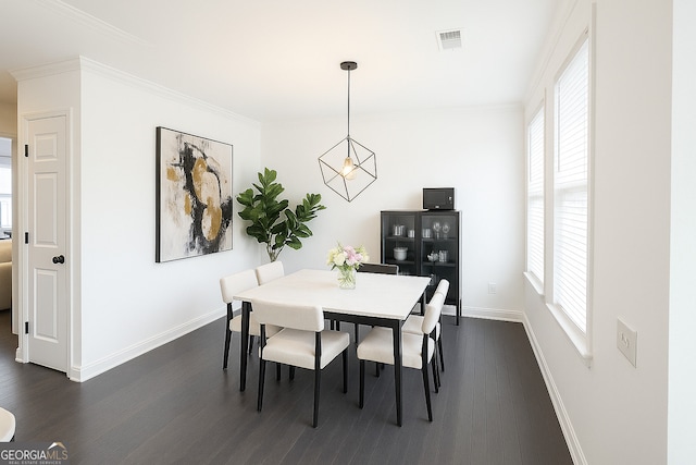 dining area with baseboards, dark wood-type flooring, healthy amount of natural light, and ornamental molding